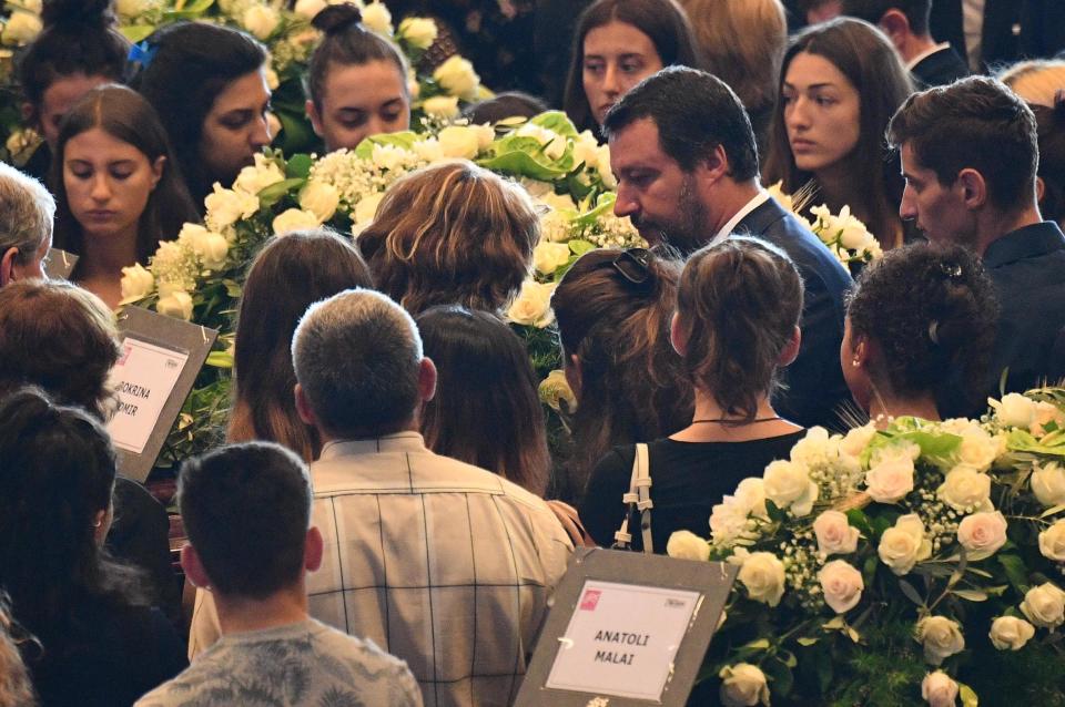 Italian Interior Minister Matteo Salvini, second from right, speaks to relatives of the victims of a collapsed highway bridge, ahead of a funeral service, in Genoa's exhibition center Fiera di Genova, Italy, Saturday, Aug. 18, 2018. Saturday has been declared a national day of mourning in Italy and includes a state funeral at the industrial port city's fair grounds for those who plunged to their deaths as the 45-meter (150-foot) tall Morandi Bridge gave way Tuesday (Luca Zennaro/ANSA via AP)