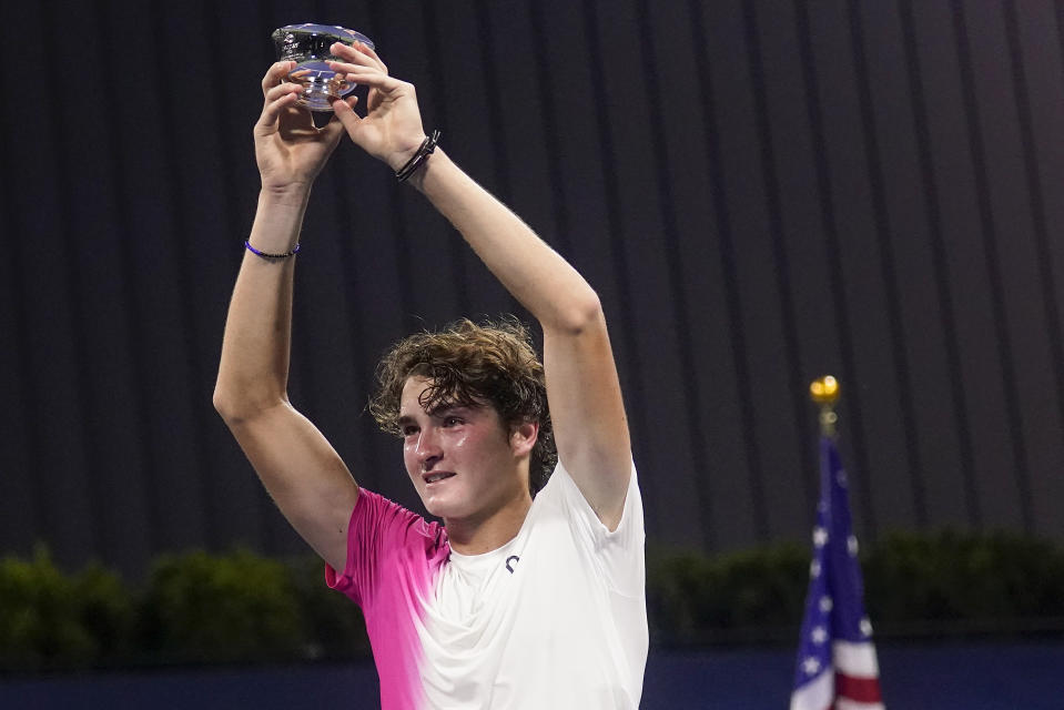 Joao Fonseca, of Brazil, holds the championship trophy after defeating Learner Tien, of the United States, in the junior boys singles final of the U.S. Open tennis championships, Saturday, Sept. 9, 2023, in New York. (AP Photo/Charles Krupa)