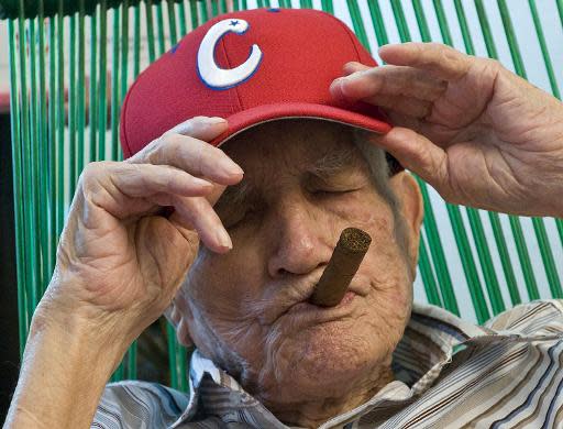 La leyenda del béisbol cubano Conrado Marrero posa con una gorra y un habano al celebrar su 100 cumpleaños el 25 de abril de 2011 (AFP/Archivos | Str)