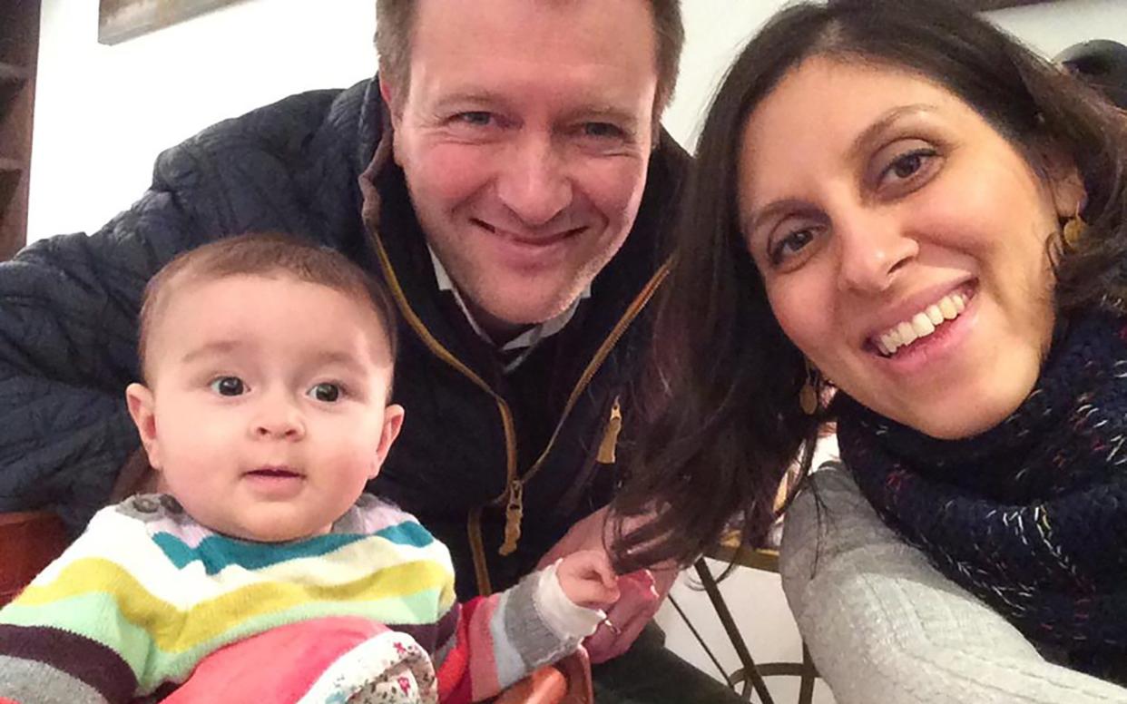 Nazanin Zaghari-Ratcliffe (R) posing for a photograph with her husband Richard and daughter Gabriella (L) - AFP