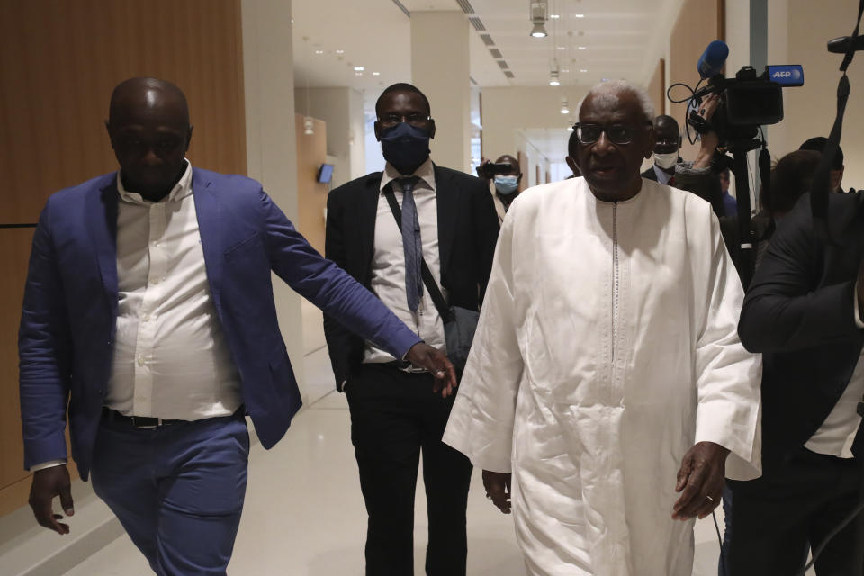 Former president of the IAAF (International Association of Athletics Federations) Lamine Diack, right, arrives at the Paris courthouse, Wednesday, June 10, 2020. A sweeping sports corruption trial opened Monday in Paris involving allegations of a massive doping cover-up that reached to the top of world track and field's governing body. Lamine Diack, 87, who served as president of the body for nearly 16 years, is among those accused of receiving money from Russian athletes to hide their suspected doping so they could compete at the Olympics in 2012 and other competitions. (AP Photo/Thibault Camus)