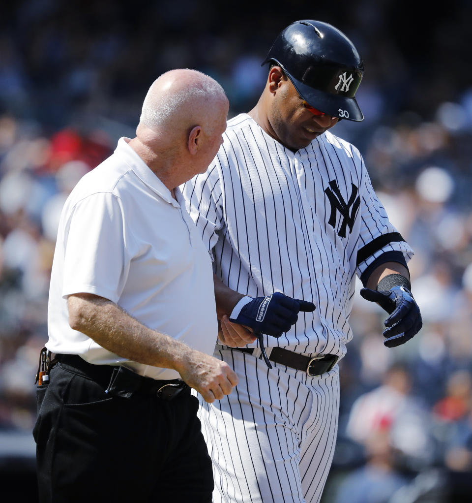 ADDS NAME OF TRAINER - New York Yankees' Edwin Encarnacion is helped by trainer Steve Donohue after being hit by a pitch thrown by Boston Red Sox's Josh Smith during the eighth inning of a baseball game Saturday, Aug. 3, 2019, in New York. Encarnacion suffered a broken right wrist. (AP Photo/Michael Owens)