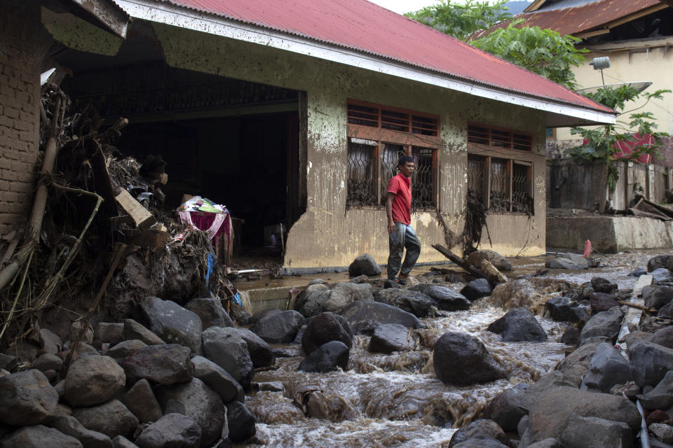 A man walks among the rubble near a house damaged by a flash flood in Agam, West Sumatra, Indonesia, Monday, May 13, 2024. Rescuers recovered more bodies Monday after monsoon rains triggered flash floods on Indonesia's Sumatra Island, bringing down torrents of cold lava and mud, leaving a number of people killed and missing. (AP Photo/Fachri Hamzah)