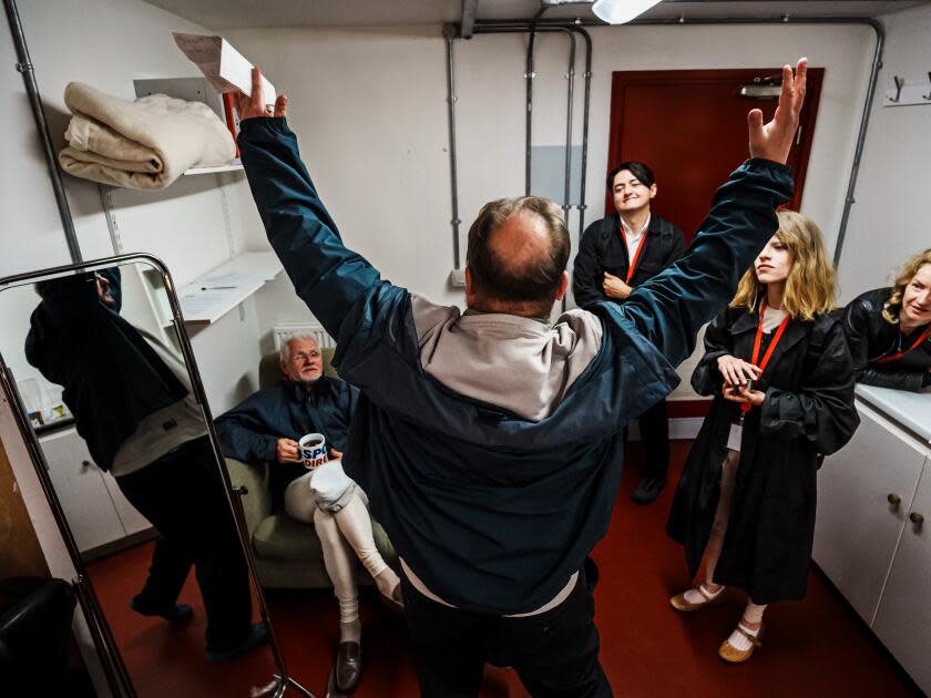 Viacheslav Yehorov, center, expresses himself to his cast members and gives them directorial notes in the dressing room.