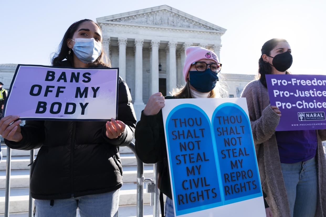 Caroline McDonald, left, a student at Georgetown University, Lauren Morrissey, with Catholics for Choice, and Pamela Huber, of Washington, join a abortion-rights rally outside the Supreme Court, Monday, Nov. 1, 2021, as arguments are set to begin about abortion by the court, on Capitol Hill in Washington. (AP Photo/Jacquelyn Martin)