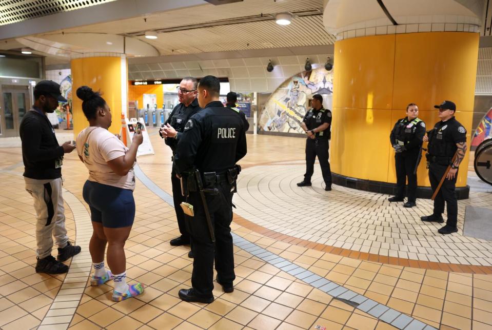 A couple converse with two uniformed officers.