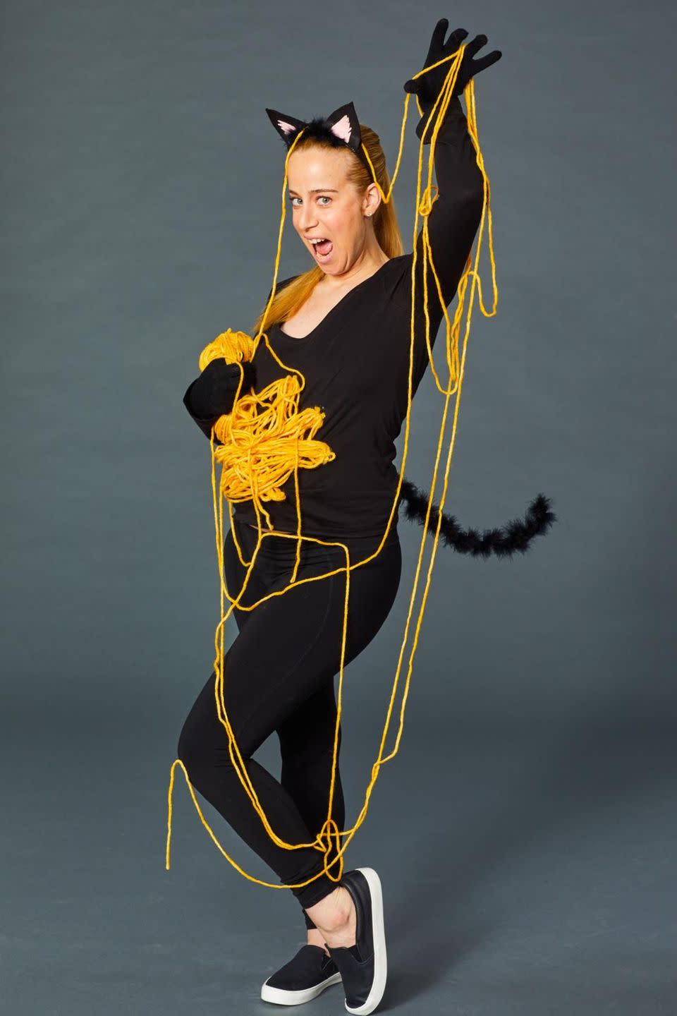 <p>Create your own spin on the <a href="https://www.goodhousekeeping.com/holidays/halloween-ideas/a24184841/diy-cat-costume/" rel="nofollow noopener" target="_blank" data-ylk="slk:classic cat costume;elm:context_link;itc:0;sec:content-canvas" class="link ">classic cat costume</a> by adding a "ball of yarn" on your baby bump. Start by looping the yarn over and over into several loops — don't worry about it being perfect, the idea is for it to be messy. Then pin the ends of the loops onto your shirt to create a "ball" effect, and let the rest of the yarn spill out for you to play with. </p>