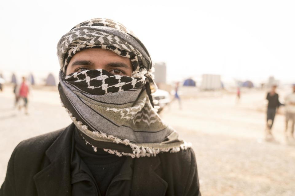 Azhar Yonas, a former policeman covering his face for fear of identification by Islamic State militants, poses for a portrait at Khazer Camp, Iraq, in this Wednesday, Nov. 9, 2016 photo. Yonas and his wife Noura Ali, said they lived in hiding during the Islamic State group’s rule over Mosul, moving an estimated 100 times because the militants were systematically killing police officers. (AP Photo/Nish Nalbandian)