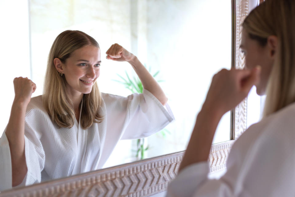 woman pumping herself up in the mirror