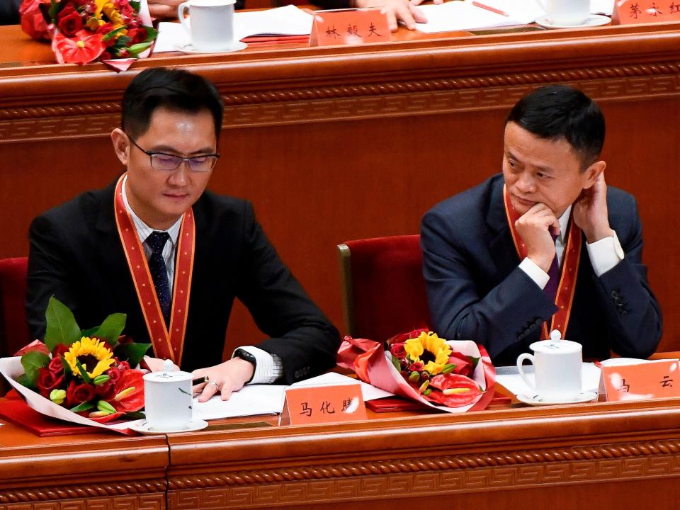 Alibaba's co-founder Jack Ma (R) looks at Tencent Holdings' CEO Pony Ma during a celebration meeting marking the 40th anniversary of China's &quot;reform and opening up&quot; policy at the Great Hall of the People in Beijing on December 18, 2018.