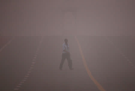 A man crosses a road amidst the heavy smog in New Delhi, India, November 6, 2016. REUTERS/Adnan Abidi