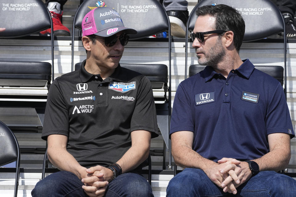 Helio Castroneves, left, of Brazil, talks with Jimmie Johnson during the drivers meeting for the Indianapolis 500 auto race at Indianapolis Motor Speedway, Saturday, May 28, 2022, in Indianapolis. (AP Photo/Darron Cummings)