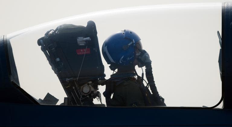 A female pilot sits in a fighter jet of the People's Liberation Army Air Force at the Airshow China 2014 in Zhuhai, south China's Guangdong province on November 11, 2014