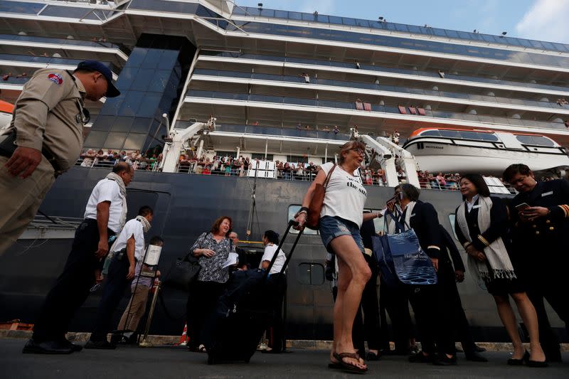 Passengers of MS Westerdam, a cruise ship that spent two weeks at sea after being turned away by five countries over fears that someone aboard might have the coronavirus, get off as it docks in Sihanoukville,