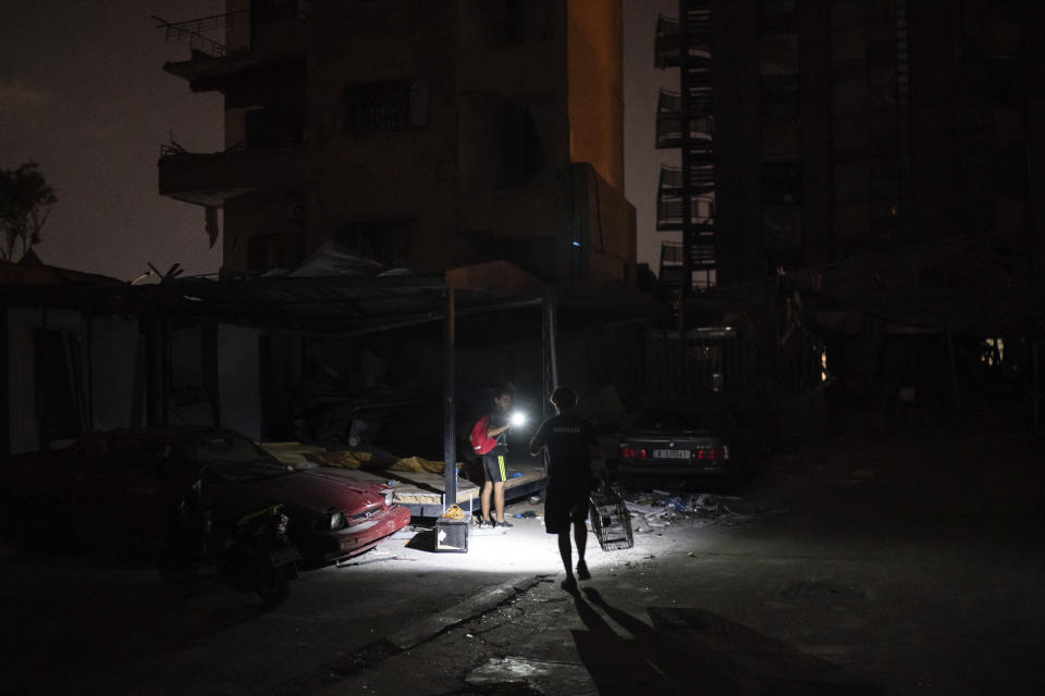 Kamal Khatib, of Animals Lebanon, carries a cage trap as he prepares to rescue a family of cats hiding among debris of a damaged building near the site of last week's massive explosion in Beirut, Lebanon, Thursday, Aug. 13, 2020.Teams go out at night and early mornings to search for the pets. Streets crowded with people, going through what remains of their building, and noisy bulldozers and lift forks are keeping the pets in hiding. (AP Photo/Felipe Dana)