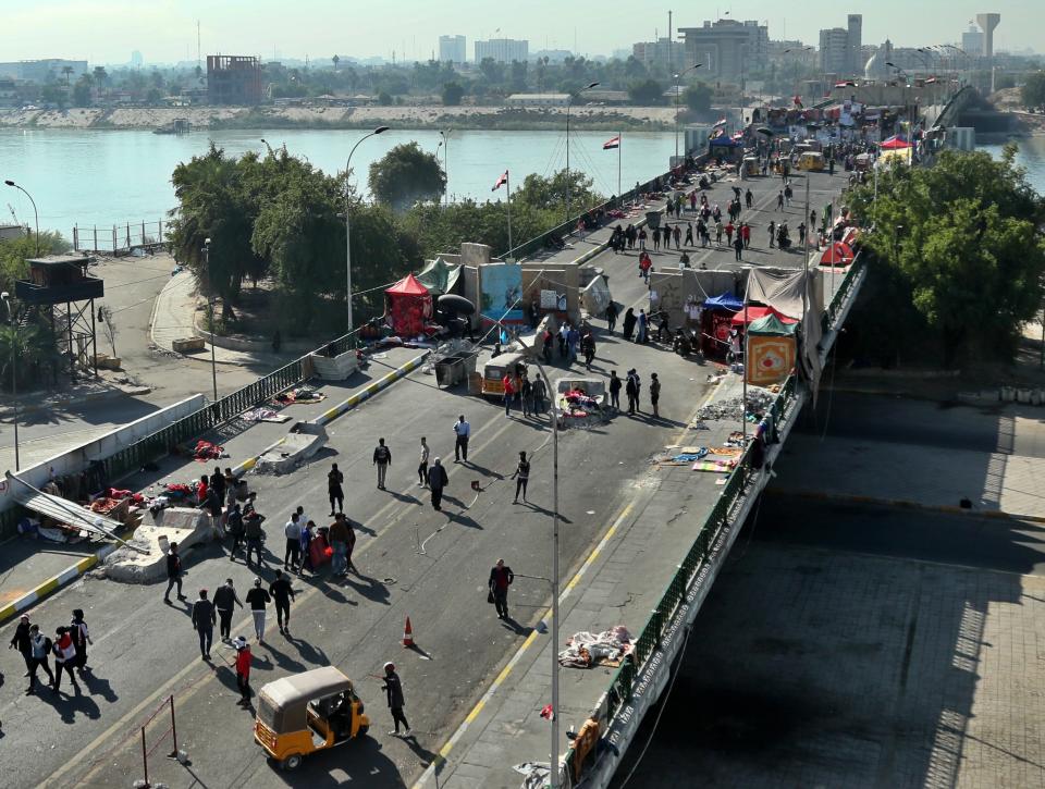 Protesters stage a sit-in between barriers at the Sinak Bridge in Baghdad, Iraq, Thursday, Nov. 21, 2019. Renewed clashes overnight in Baghdad between anti-government demonstrators and security forces killed and wounded protesters, security and hospital officials said Thursday. (AP Photo/Hadi Mizban)