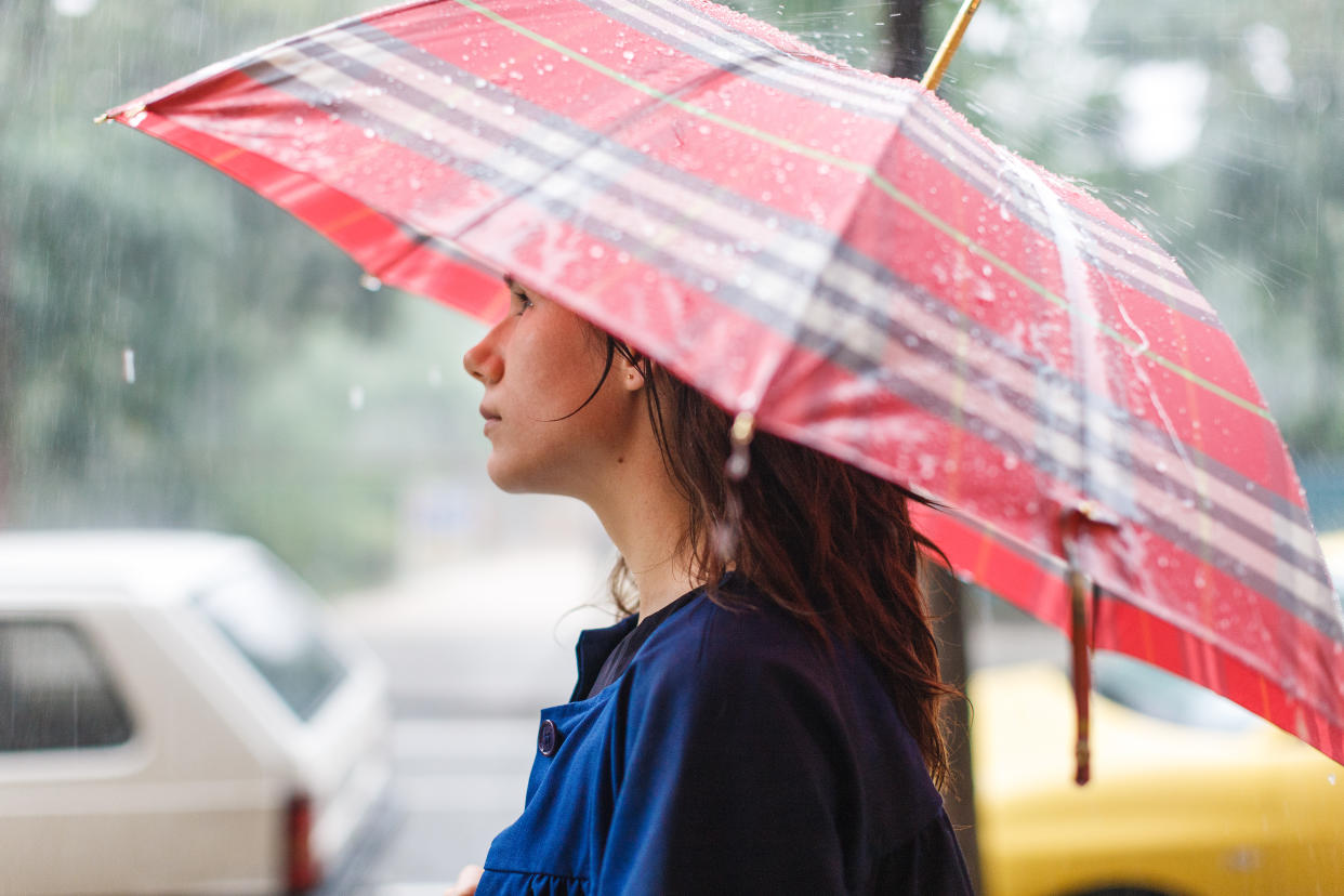 Young woman under umbrella in rain