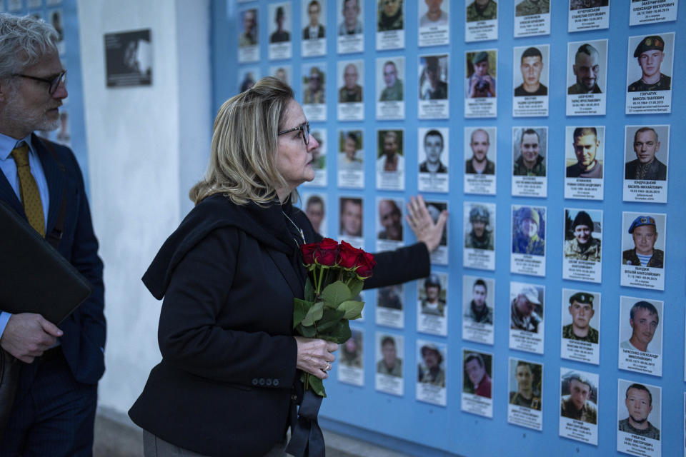 U.S. representative Madeleine Deane, D-Pa, places flowers at a memorial wall of Ukrainian soldiers killed during the war at Saint Michael cathedral in Kyiv, Ukraine, Monday, April 22, 2024. A bipartisan delegation of U.S. Congress members met President Volodymyr Zelenskyy in Kyiv on Monday and praised the historic House vote to approve $61 billion in military aid for Ukraine. (AP Photo/Francisco Seco)