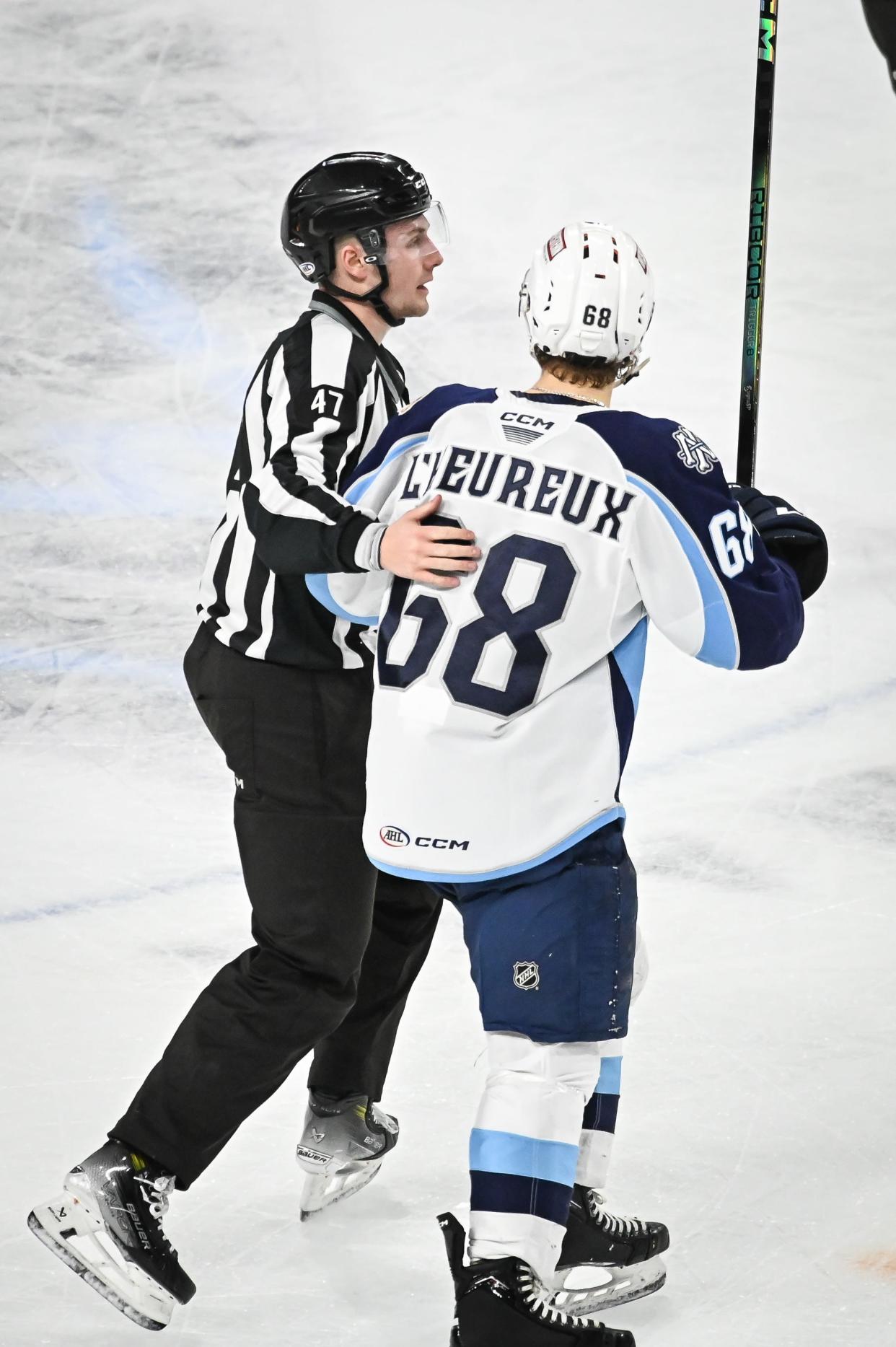 Milwaukee Admirals left wing Zach L'Heureux (68) is escorted off the ice after drawing a game misconduct penalty for unsportsmanlike conduct in his behavior toward officials in a game against the Texas Stars on Saturday, January 20, 2024, at the UW-Milwaukee Panther Arena in Milwaukee, Wisconsin.