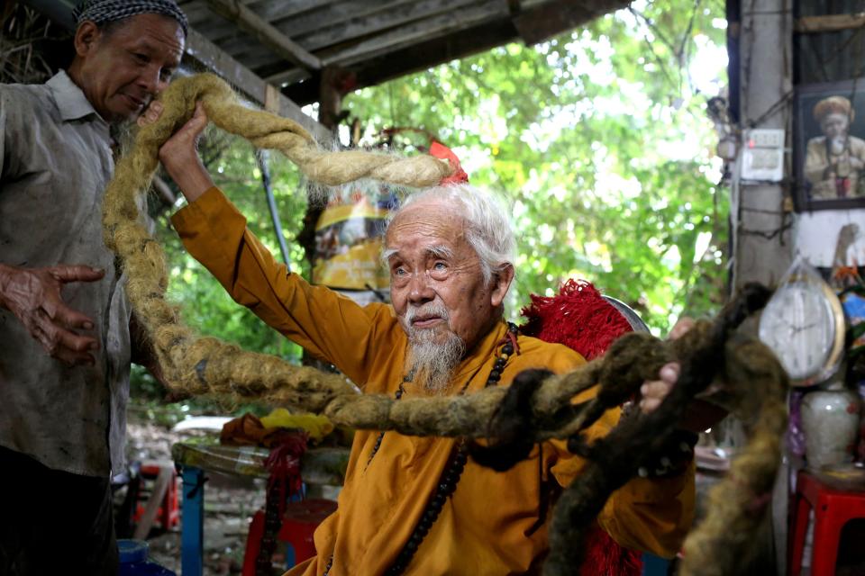 Nguyen Van Chien, 92, sits for a portrait to show his 5-meter long hair which, according to him, has not been cut for nearly 80 years, at his home in Tien Giang province, Vietnam , August 21, 2020. Picture taken August 21, 2020. REUTERS/Yen Duong