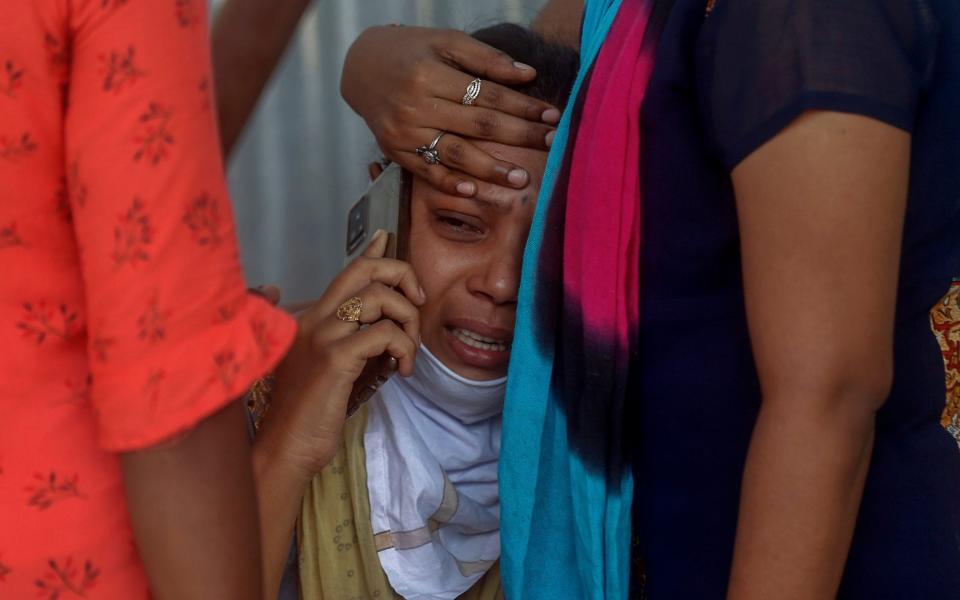 Relatives outside a hospital in Mumbai - Rafiq Maqbool /AP