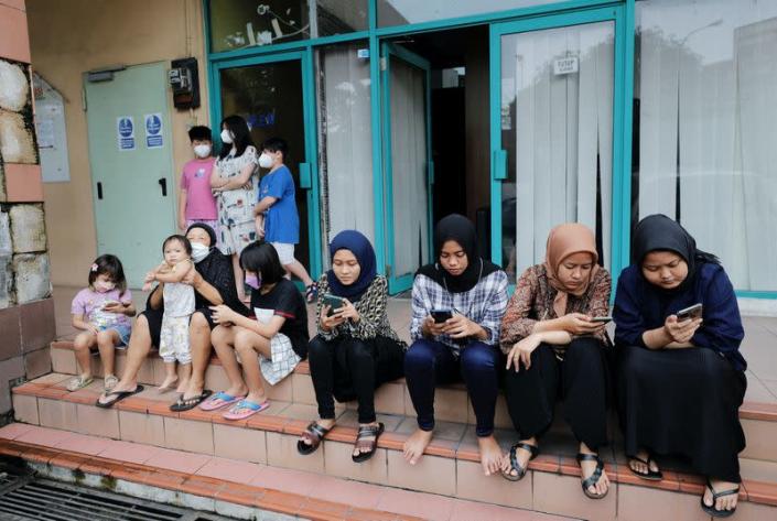 People gather outside an apartment building as they are evacuated following an earthquake in Jakarta