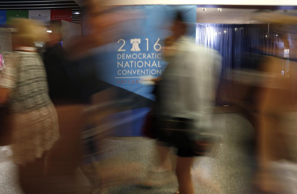 FILE - In this July 28, 2016, file photo attendees walk a hall in the Wells Fargo Center before the start of the final day of the Democratic National Convention in Philadelphia. The coronavirus pandemic is forcing Democrats and Republicans to take a close look at whether they'll be able to move forward as planned this summer with conventions that typically kick off the general election season. (AP Photo/Paul Sancya, File)