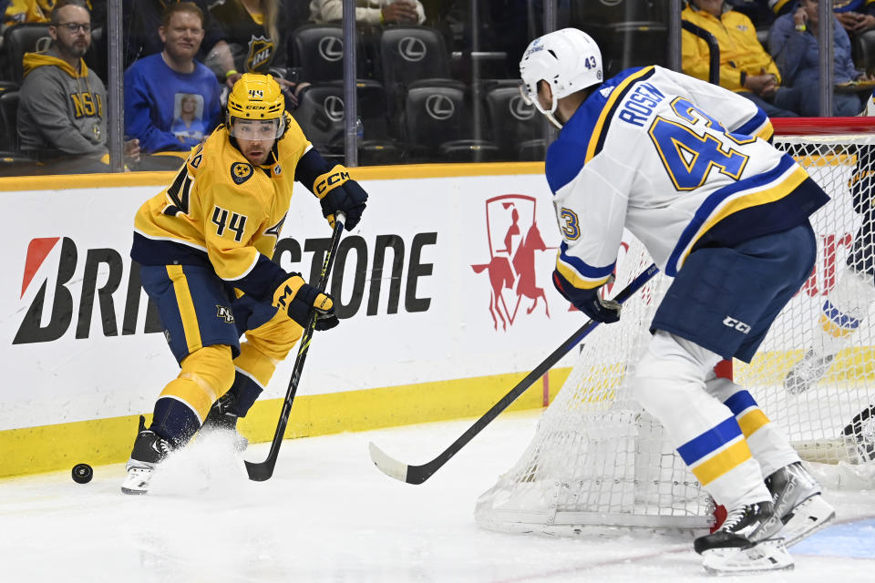 Nashville Predators left wing Kiefer Sherwood (44) tries to get control of the puck as St. Louis Blues defenseman Calle Rosen (43) skates in during the second period of an NHL hockey game Saturday, April 1, 2023, in Nashville, Tenn. (AP Photo/Mark Zaleski)