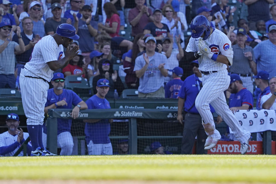 Chicago Cubs' Seiya Suzuki, right, bows to third base coach Willie Harris, left, after hitting a home run against the Cincinnati Reds during the eighth inning of a baseball game, Thursday, Sept. 8, 2022, in Chicago. (AP Photo/David Banks)