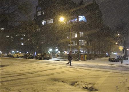 A man walks through the West Village neighbourhood as snow begins to fall in New York January 2, 2014. REUTERS/Gary Hershorn