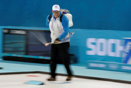 FILE PHOTO: A staff member sprays water onto the sheet before the women's bronze medal curling game between Switzerland and Britain at the Ice Cube Curling Centre during the Sochi 2014 Winter Olympics February 20, 2014. REUTERS/Phil Noble/File Photo