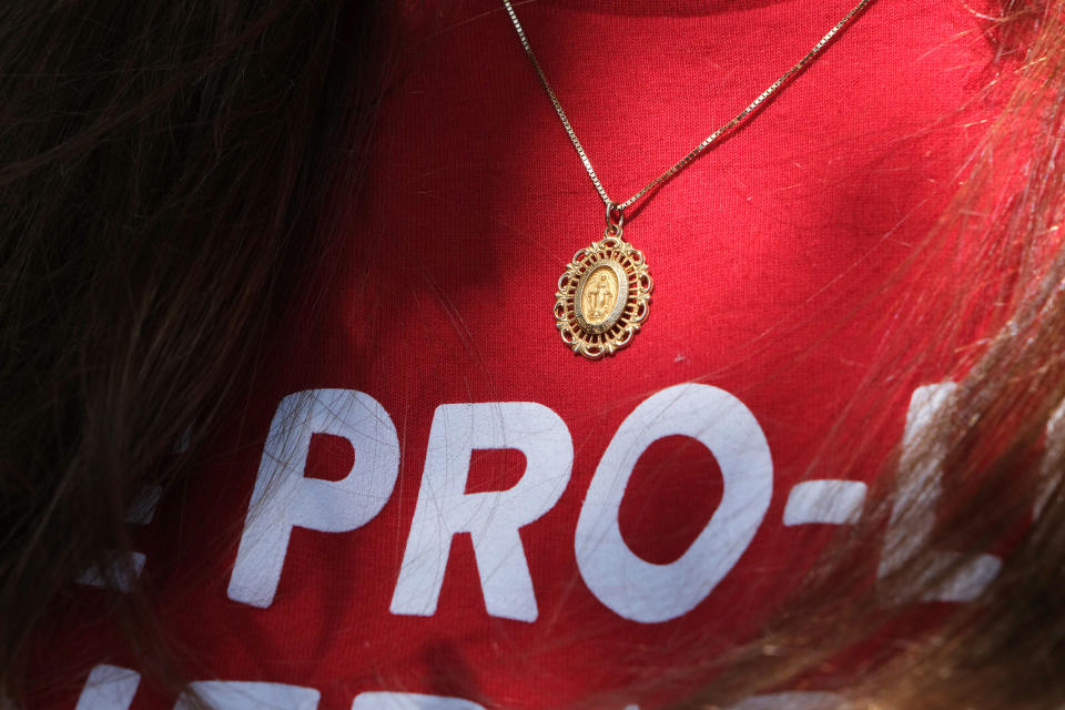 A volunteer with Students for Life of America wears a Miraculous Medal pendant and a shirt that says "The Pro-Life Generation Votes" while canvassing on July 23.<span class="copyright">Arin Yoon for TIME</span>