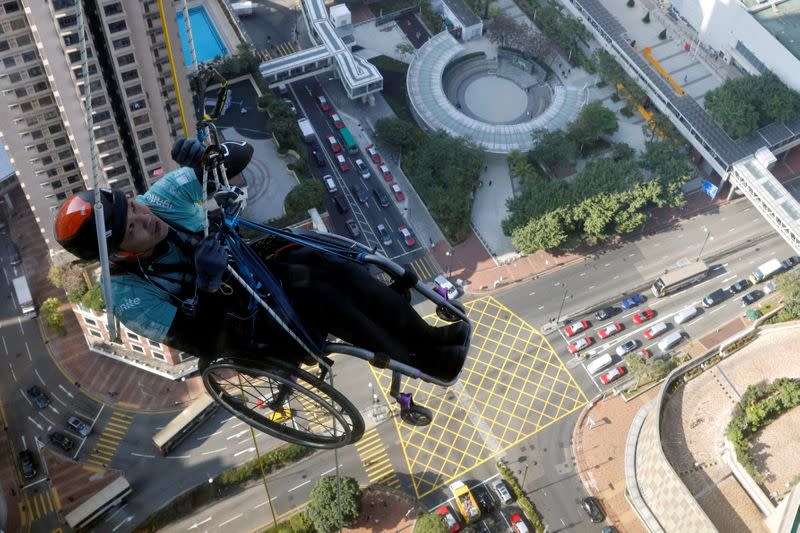 Lai Chi-wai, a paraplegic climber, attempts to climb the 320-metre tall Nina Tower using only his upper body strength, in Hong Kong