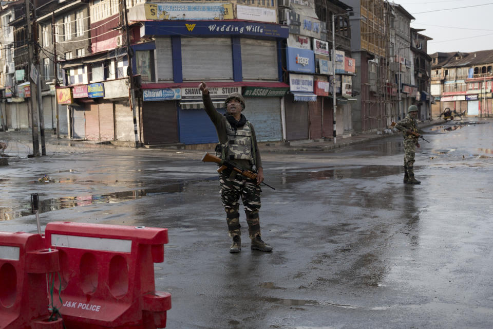 Indian Paramilitary soldiers stand guard on a deserted street during curfew in Srinagar, Indian controlled Kashmir, Thursday, Aug. 8, 2019. The lives of millions in India's only Muslim-majority region have been upended since the latest, and most serious, crackdown followed a decision by New Delhi to revoke the special status of Jammu and Kashmir and downgrade the Himalayan region from statehood to a territory. Kashmir is claimed in full by both India and Pakistan, and rebels have been fighting Indian rule in the portion it administers for decades. (AP Photo/Dar Yasin)