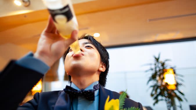 A young Japanese man is drinking beer.