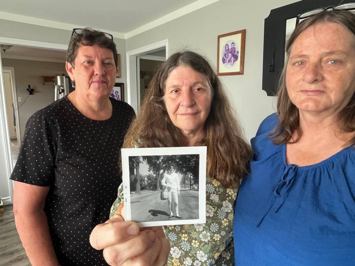 Trudy White holds a 1962 photograph of her missing aunt. White's sister, Cheryl Collings, right, and cousin Pauline Campbell are among Eileen Faye Williams's family members who want to know what happened.  (Brian Higgins/CBC - image credit)