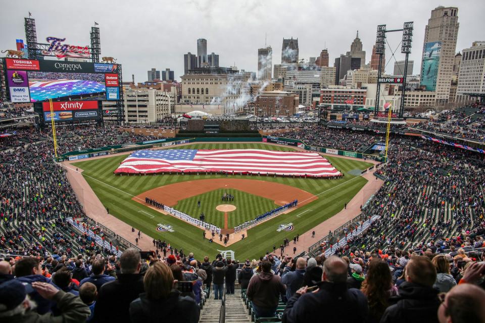 The national anthem is sung by original Supreme Mary Wilson, as jet fighters fly over and the American flag is displayed, during the Detroit Tigers' Opening Day game against the Kansas City Royals at Comerica Park on Thursday, April 4, 2019.