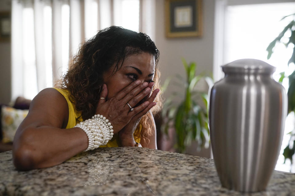 Daphne Bolton wipes away tears as she looks at an urn containing the ashes of her brother at her home on Monday, May 31, 2021, in Charlotte, N.C. Bolton's brother, Johnny Lorenzo Bolton, a 49-year-old Black man was shot shoot to death by a Cobb County Sheriff's Office SWAT team member serving a search warrant last December. (AP Photo/Chris Carlson)