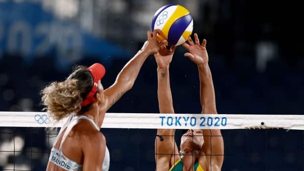 Canada's Brandie Wilkerson, left, attempts a kill on Brazil's Agatha Bednarczuk in their final match of Group play at the 2020 Toyko Olympic Games on Thursday. (Pilar Olivares/Reuters - image credit)