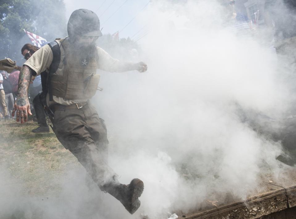 <p>A White Supremacist kicks back a smoke bomb thrown by counter protestors during clashes at Emancipation Park where the White Nationalists are protesting the removal of the Robert E. Lee monument in Charlottesville, Va., on Aug. 12, 2017. (Photo: Samuel Corum/Anadolu Agency/Getty Images) </p>