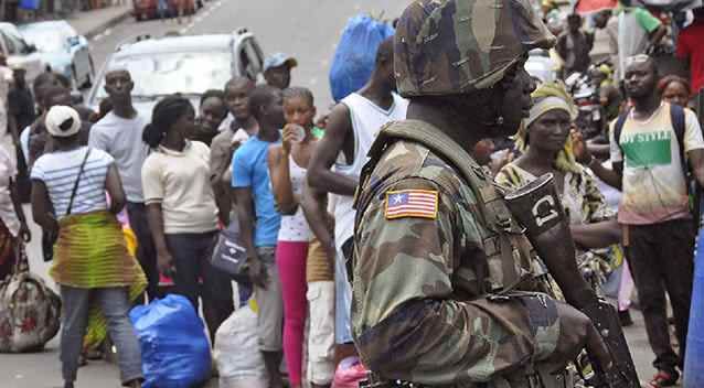 A Liberian soldier scans people for signs of the Ebola virus. Picture: AP