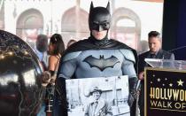 Batman hält - in Form eines Fotos - seinen Schöpfer in Ehren: Fast zeitgleich mit "Superman" erschien 1939 auch der erste Comic über den als Fledermaus verkleideten Milliardär namens Bruce Wayne, der gegen Verbrecher in seiner Heimatstadt Gotham City kämpft. (Bild: Alberto E. Rodriguez/Getty Images)