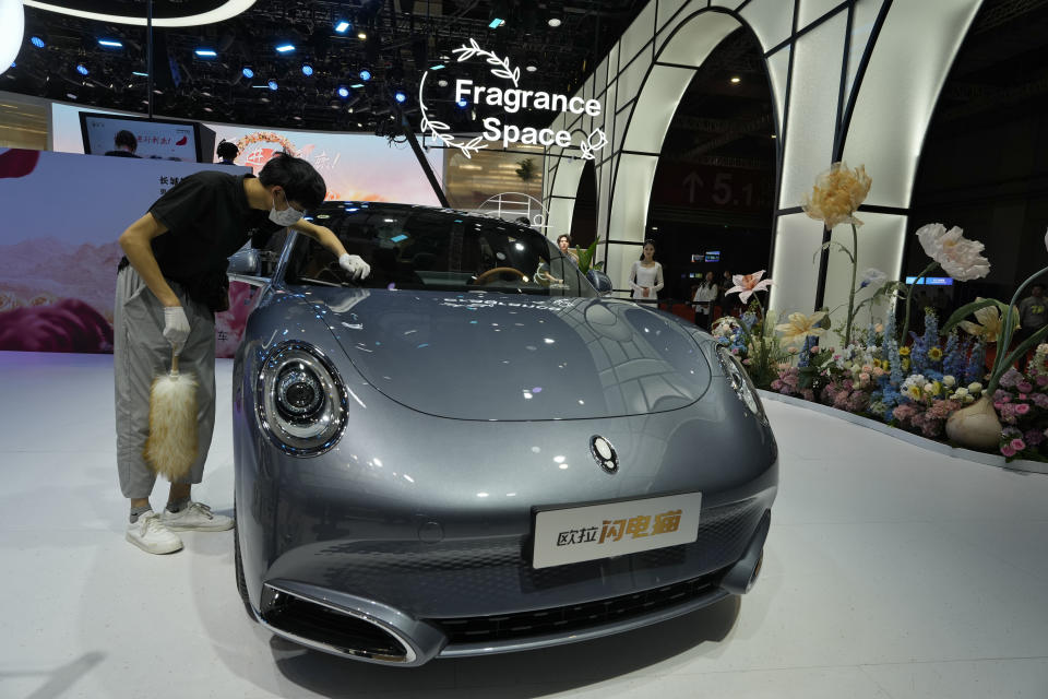 A worker wipes an Ora, a Chinese-made electric car brand during the Auto Shanghai 2023 at the National Exhibition and Convention Center in Shanghai, China, Tuesday, April 18, 2023. Global and Chinese automakers plan to unveil more than a dozen new electric SUVs, sedans and muscle cars this week at the Shanghai auto show, their first full-scale sales event in four years in a market that has become a workshop for developing electrics, self-driving cars and other technology. (AP Photo/Ng Han Guan)