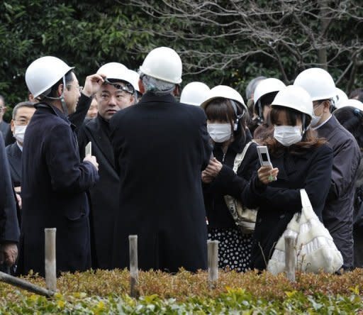 People stand outside a building in Tokyo following a major 8.9 magnitude quake which hit Japan. The strongest earthquake ever to hit Japan has unleashed a terrifying 10-metre tsunami that washed away homes and tossed ships inland, with a nuclear plant among multiple sites set ablaze