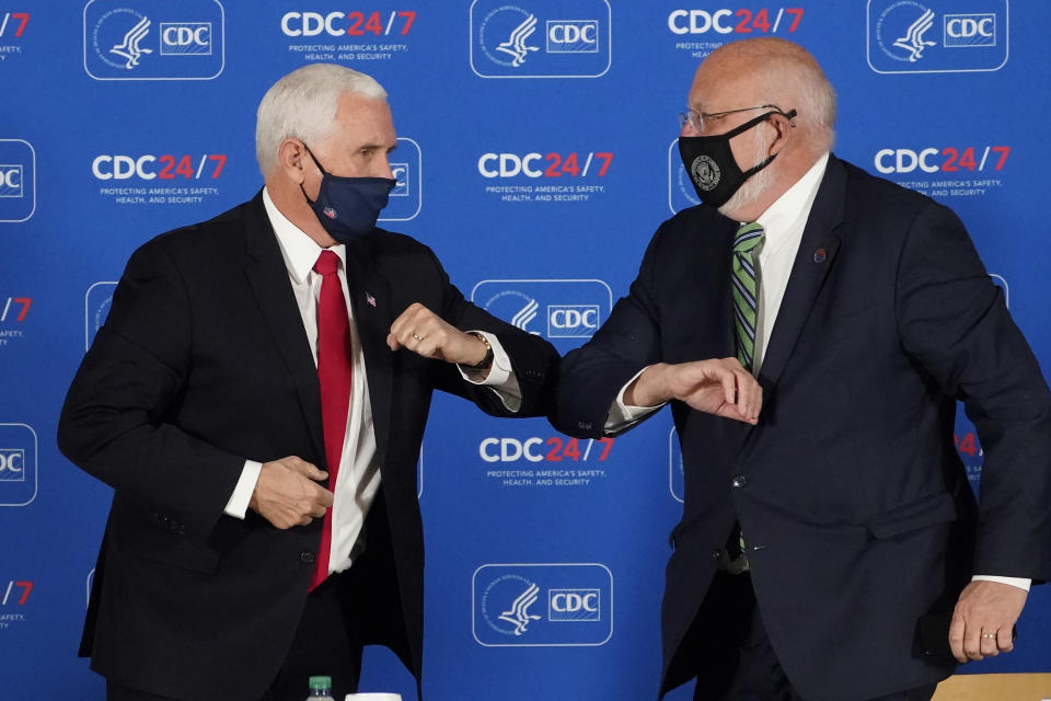 Vice President Mike Pence, left, and Centers for Disease Control and Prevention director Dr. Robert Redfield exchange elbow bumps after a briefing at the CDC Friday, Dec. 4, 2020, in Atlanta. (AP Photo/John Bazemore)