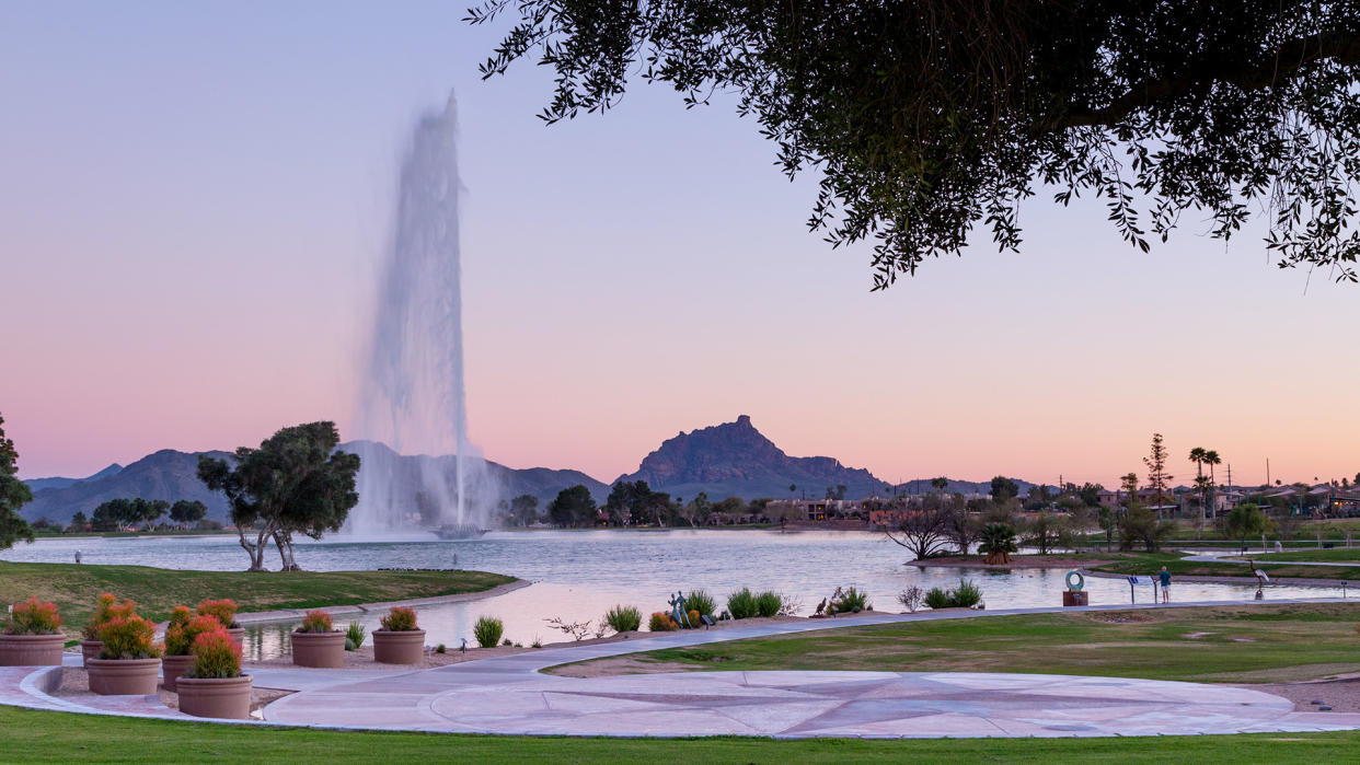 Pink sky behind one of the tallest fountains in the world in Fountain Hills, AZ with Fire Rock and Four Peaks in the background - Image.