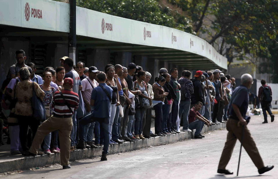 Gente aguarda transporte público en medio del apagón más prolongado y extendido de la historia de Venezuela, en Caracas, 8 de marzo de 2019. Para el sábado 9 de marzo de 2019 el servicio se había restaurado en algunas partes derl país, y en otras había apagones intermitentes. (AP Foto/Eduardo Verdugo)