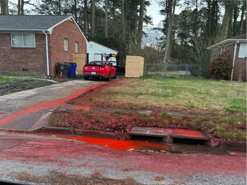 <em>A photo of the dye running from a Norfolk driveway into the storm drain (Courtesy of a WAVY viewer) </em>
