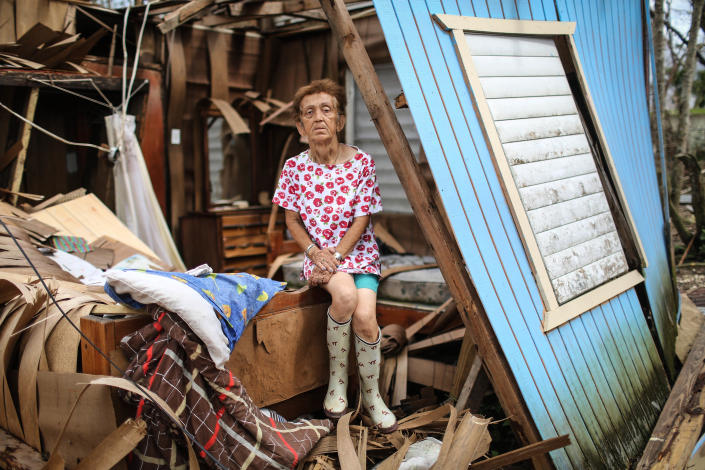 <p>Sonia Torres poses in her destroyed home, while taking a break from cleaning, three weeks after Hurricane Maria hit the island, on Oct. 11, 2017 in Aibonito, Puerto Rico. (Photo: Mario Tama/Getty Images) </p>