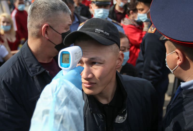 People wait in line to enter the city at a check point on the outskirts of Almaty